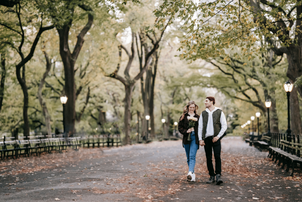 Couple holding hands at the park with flowers