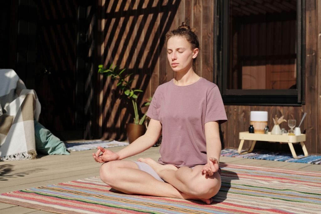 Woman meditating peacefully with eyes closed representing the theta brain wave state of deep relaxation