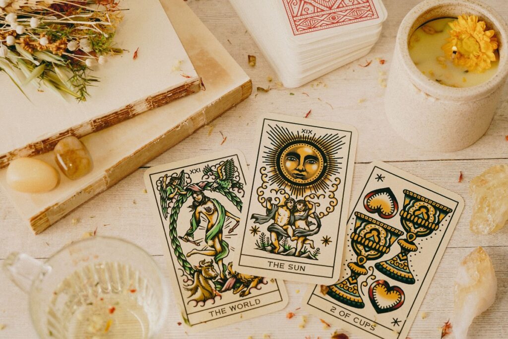 Three tarot cards laid out in a past present future spread on a reading table