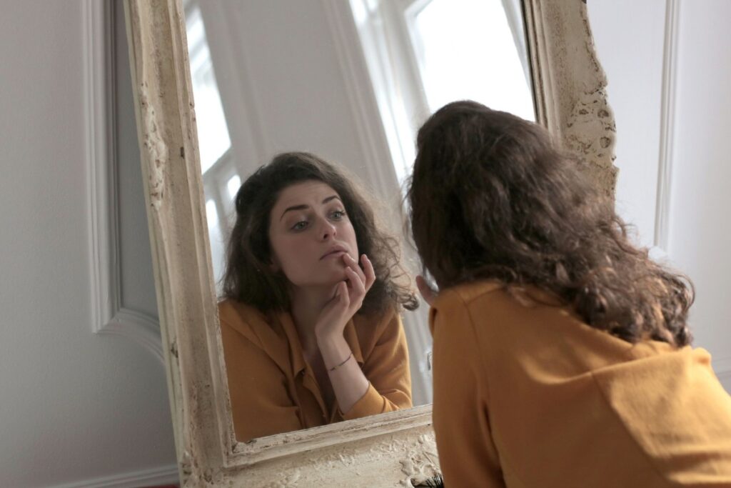 Person practicing positive financial affirmations in front of a mirror